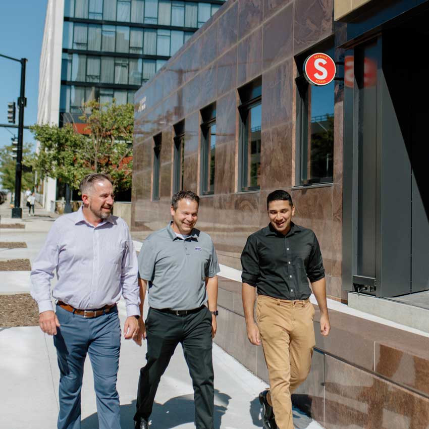 a group of three people walking down a street